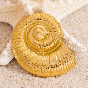 18K gold-plated stainless steel conch shell brooch on white starfish in beach sand