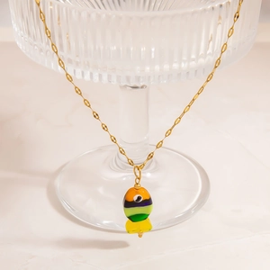 Detail of artistic layered colorful fish pendant on a delicate gold stainless steel chain