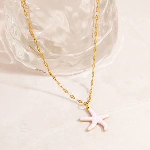 Detail of a starfish pendant with pink enamel dots on an 18K gold-plated stainless steel chain