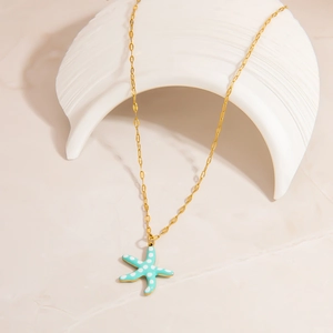 Minimalist stainless steel gold necklace featuring a blue starfish pendant on a beige background