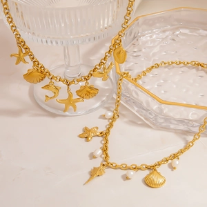 Nahaufnahme der goldenen Meereshalskette mit Seestern, Muscheln und Perlen