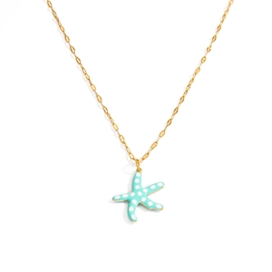 Detail of blue starfish pendant with white polka dots on a gold stainless steel chain