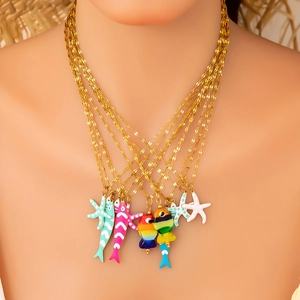Detail of layered gold starfish and fish pendants with colorful enamel on a wave chain