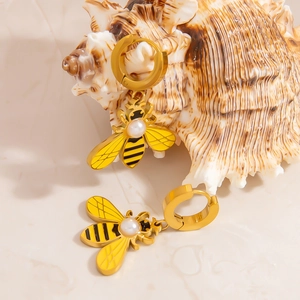 Goldene Bienen-Ohrringe mit Perle und Emaille auf einer natürlichen Muschel