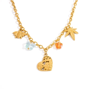 Detailansicht der Goldkette mit Schmetterlings-, Bienen- und Blumenanhängern auf Weiß