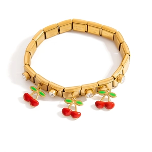 Detail of 18k gold plated modular bracelet with red cherry charms and white cubic zirconia