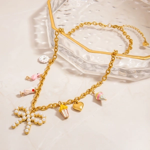 Goldene Edelstahlkette mit bunten Emaille-Anhängern und einer Perle-Schleife