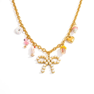 Detail der Goldkette mit Perlschleife und bunten Emaille-Anhängern wie Donuts und Flamingos