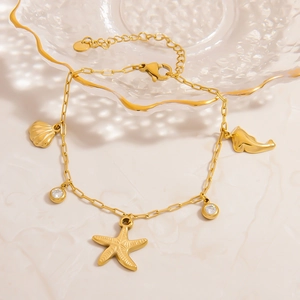 Gold beach charm bracelet with starfish, shell, whale tail and sparkling crystals