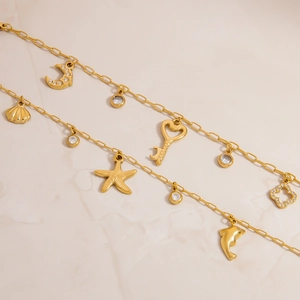 18K gold plated stainless steel bracelet featuring diverse sea themed charms and key pendant