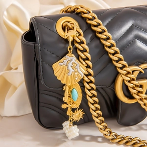 Quilted leather shoulder bag with gold chain and marine shell pearl keychain charm