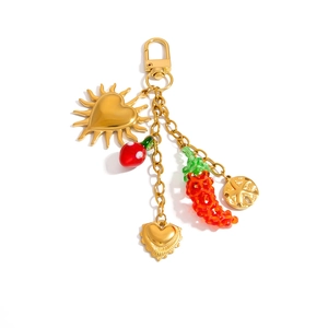 Stainless steel keychain with gold strawberry heart and chili charms on white background