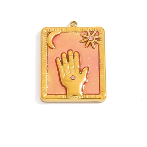 Close-up of gold tarot pendant with pink enamel and sun moon palm motifs