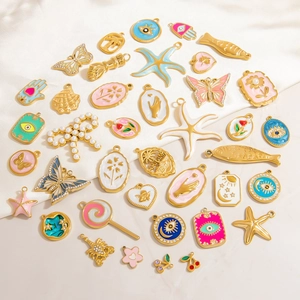 Flat lay of diverse 18K gold plated charms with colorful enamel and bohemian sea elements