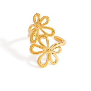 Dettaglio macro dell'anello in acciaio dorato con design floreale traforato
