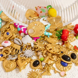 Close-up of golden stainless steel charms with enamel details for jewelry making