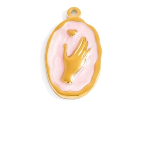 Detail of oval gold-plated pendant featuring pink enamel with hand and heart relief