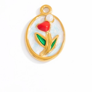 Detail of vintage gold oval pendant featuring red enamel flower and white pearl accent