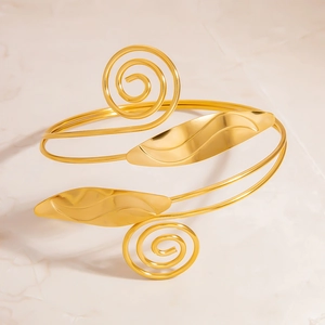 Bracelet de bras spirale doré avec motifs floraux sur fond de marbre chic