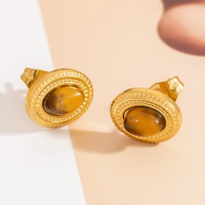 Detailed close-up of retro gold-plated earrings featuring oval tiger eye stones