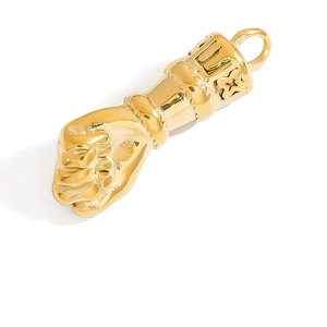 Macro view of gold-plated fist pendant featuring intricate chain details and luxury engraving