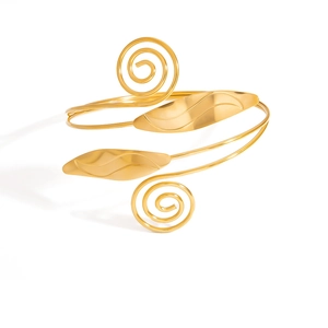 Détail d'un bracelet de bras spirale doré avec motifs de feuilles et finition polie