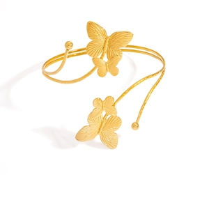 Détail macro du bracelet de bras papillon doré avec ailes texturées et bande spirale