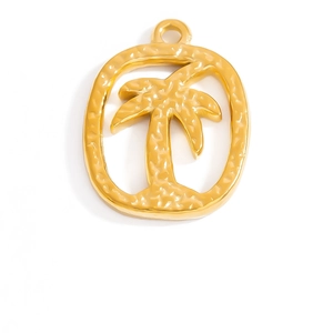 Macro detail of golden palm tree pendant with hammered texture inside oval frame