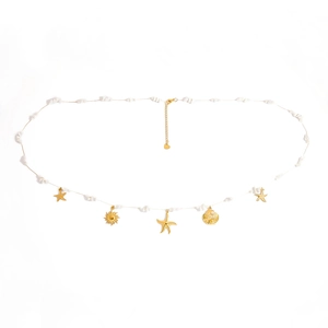 Detail of a pearl waist chain with golden sunflower and starfish pendants on white background