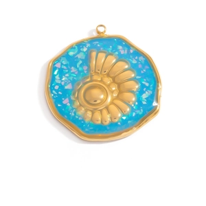 Vista macro di un ciondolo organico in oro 18K con resina blu e dettaglio a conchiglia