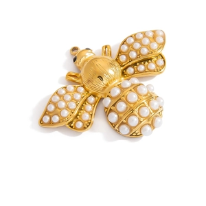 Dettaglio macro di un ciondolo ad ape in oro 18K con perle bianche e dettagli sulle ali