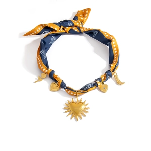 Boho Seidenschal Halskette mit goldenem Herz und Blumenanhängern auf weißem Grund