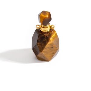Macro detail of teardrop tiger eye stone perfume bottle pendant with golden metal ring