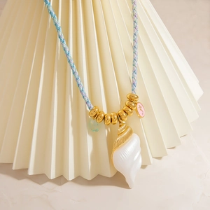 Bohemian woven rope necklace with large spiral conch shell and seahorse charm