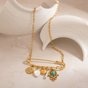 Detailed close-up of 18K gold paperclip chain with hamsa, moon, and heart charms