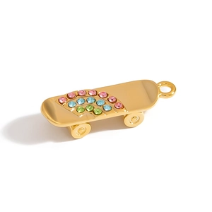 Macro detail of gold-plated skateboard pendant featuring colorful rhinestones and wheels