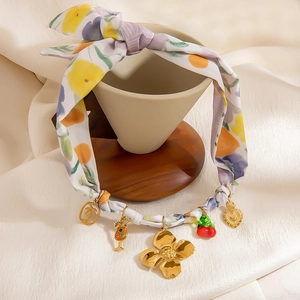 Bohemian paisley scarf necklace with 18K gold pendants on a creative display stand