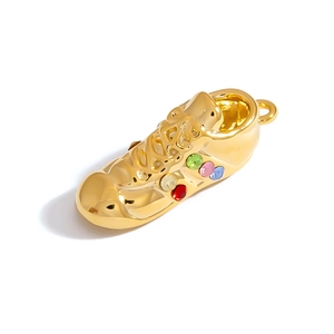 Detail of golden sneaker charm featuring colorful inset rhinestones and a secure clasp