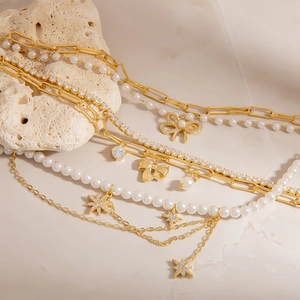 Elegantes zweilagiges Perlenarmband mit Strass-Schleifenanhänger und goldener Kette