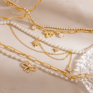 Elegantes mehrlagiges Goldarmband mit Perlen, Kristallschleifen und Sternanhängern