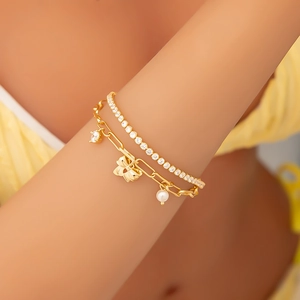 Detailaufnahme des doppelten Goldarmbands mit Kristall-Tenniskette und Perlenanhänger