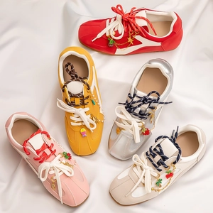 Colorful vintage mesh sneakers with stylish metal charms and layered laces on white silk