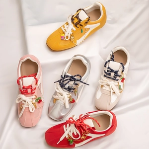 Colorful DIY sneaker charms on mesh sneakers with strawberry and star pendant decorations