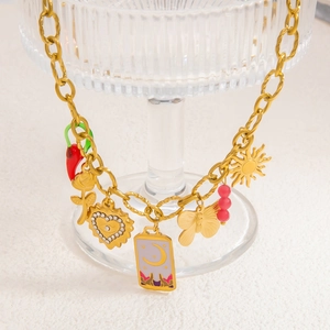 Chunky gold chain necklace with mixed charms like red chili, rose, and crescent moon