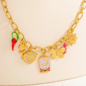 Close-up of golden stainless steel necklace with chili, heart and butterfly charms