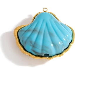 Dettaglio del ciondolo a conchiglia con trama in marmo blu e cornice dorata martellata
