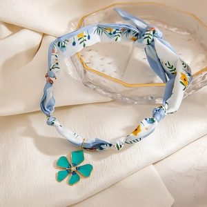 Floral print silk scarf necklace featuring a gold-plated flower pendant with a sparkling crystal