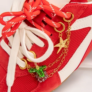 Gold star and grape bead shoe charms on a sneaker with stainless steel chains