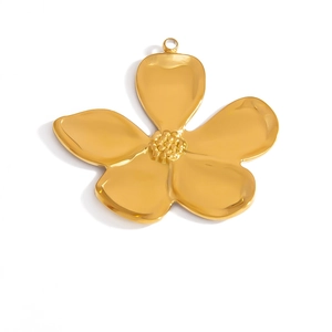 Dettaglio macro di un ciondolo a fiore dorato con petali testurizzati e anello superiore