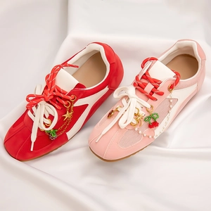 Close-up of beach style shoe charms with cherry and pearl pendants on sneakers